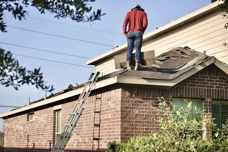 Professional roofer working on a residential roof in West Barnstable